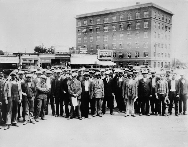 Group of unidentified men standing in the street of an unidentified town during the Depression