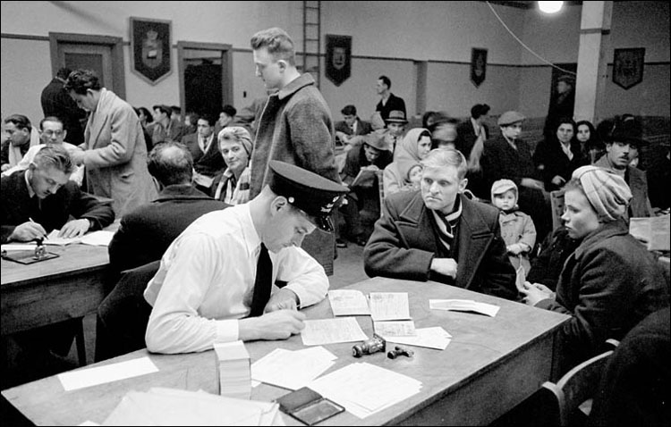 Examens des nouveaux arrivés au pays dans la salle d'examens immigration, Quai 21, Halifax, N-É, mars 1952